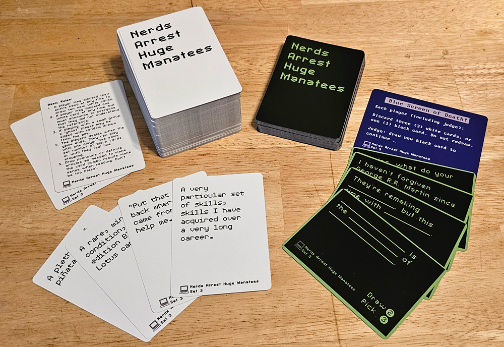 Stacks and spreads of white and black cards. The backs read "Nerds Arrest Huge Manatees." The fronts say things like "A very particular set of skills, skills I have acquired over a very long career." and "_______ is the _______ of _______."